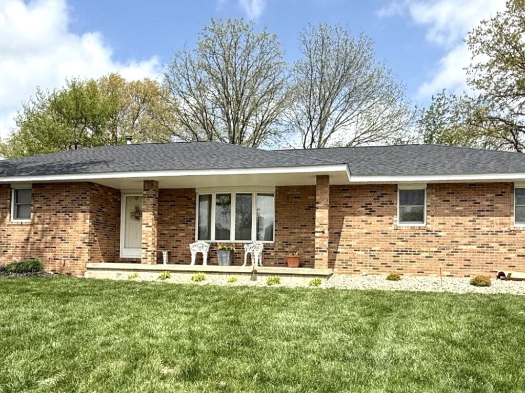 Completed roof replacement on a brick ranch home in Aviston IL with dark charcoal asphalt shingles installed by Barringer Brothers Roofing