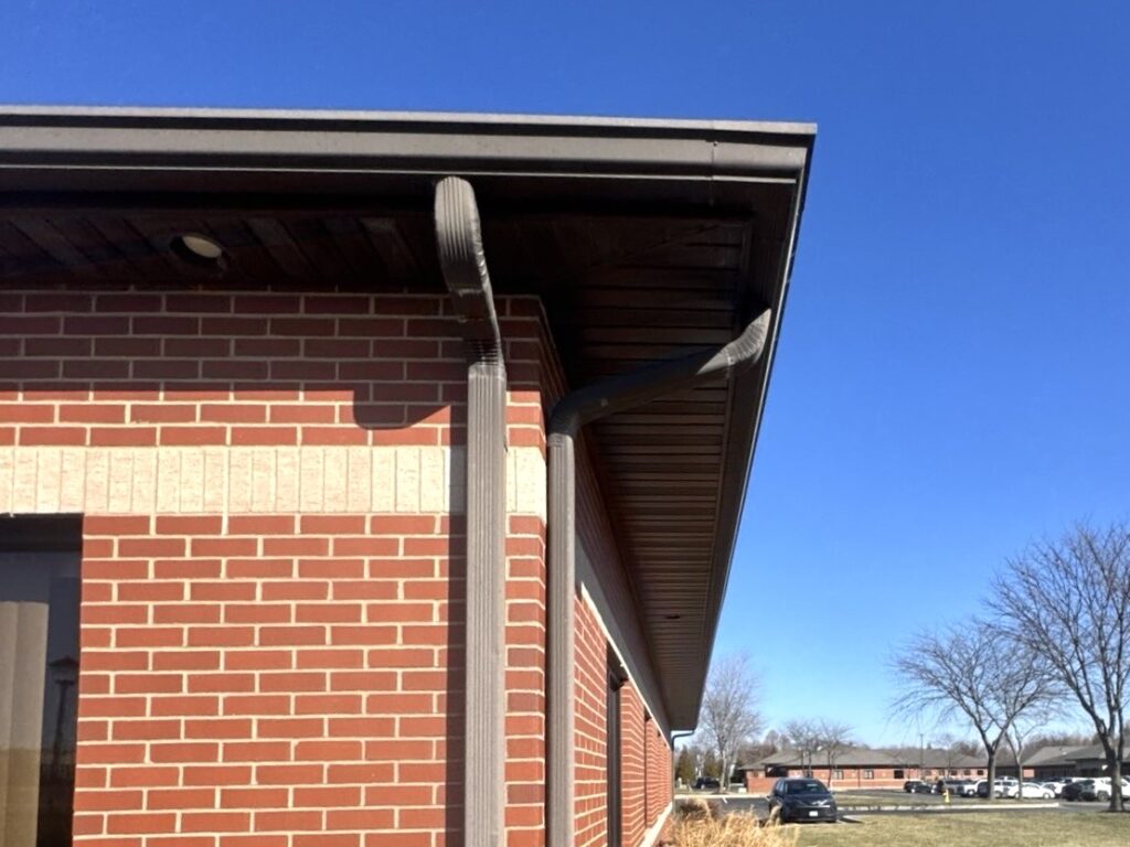 New aluminum gutter and downspout installation on a brick commercial building in O'Fallon Illinois