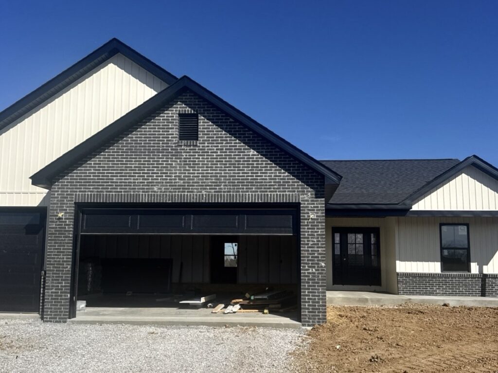 New home with board and batten siding and dark brick exterior in Waterloo IL
