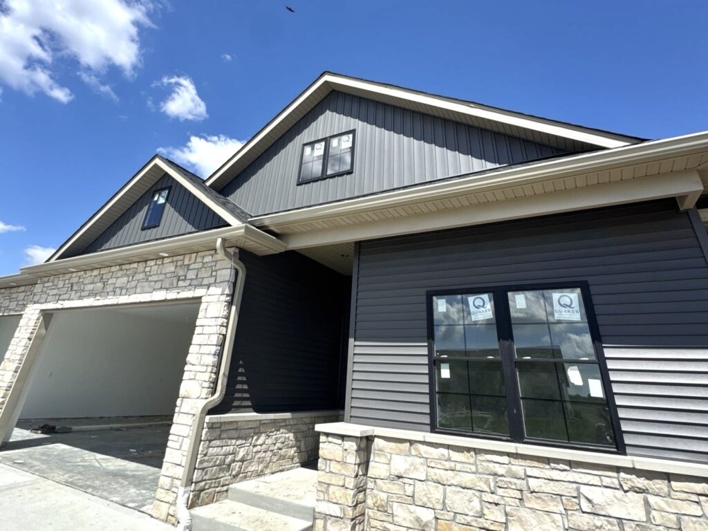 New home with dark siding and stone exterior in Troy IL installed by Barringer Brothers Roofing