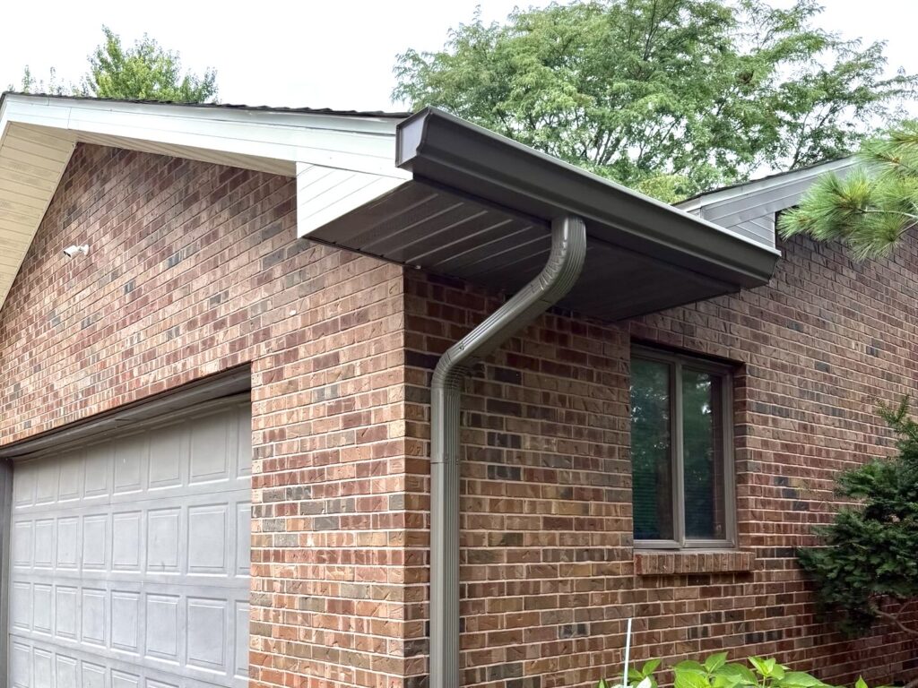 New gutter and downspout installed on a brick home in Swansea, IL by Barringer Brothers Roofing.