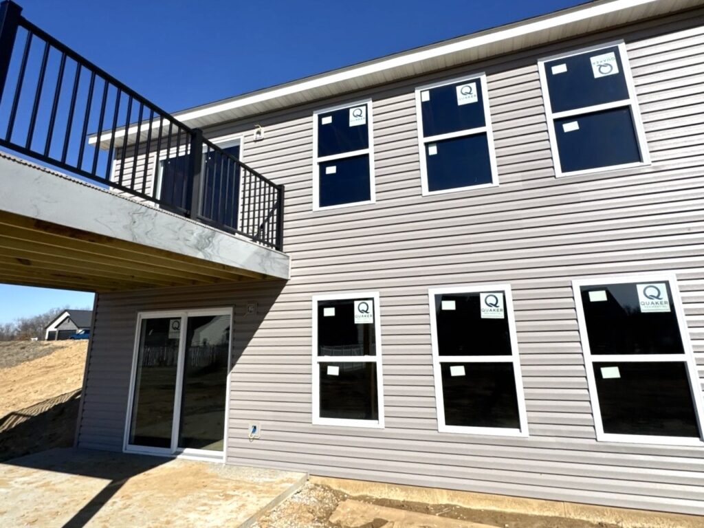 New construction home with professionally installed vinyl siding in Waterloo, IL by Barringer Brothers Roofing.