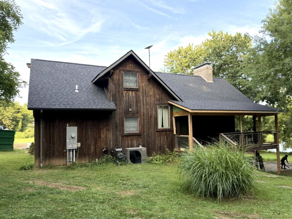 Dark asphalt shingle roof on a rustic home in Columbia, IL installed by Barringer Brothers Roofing.
